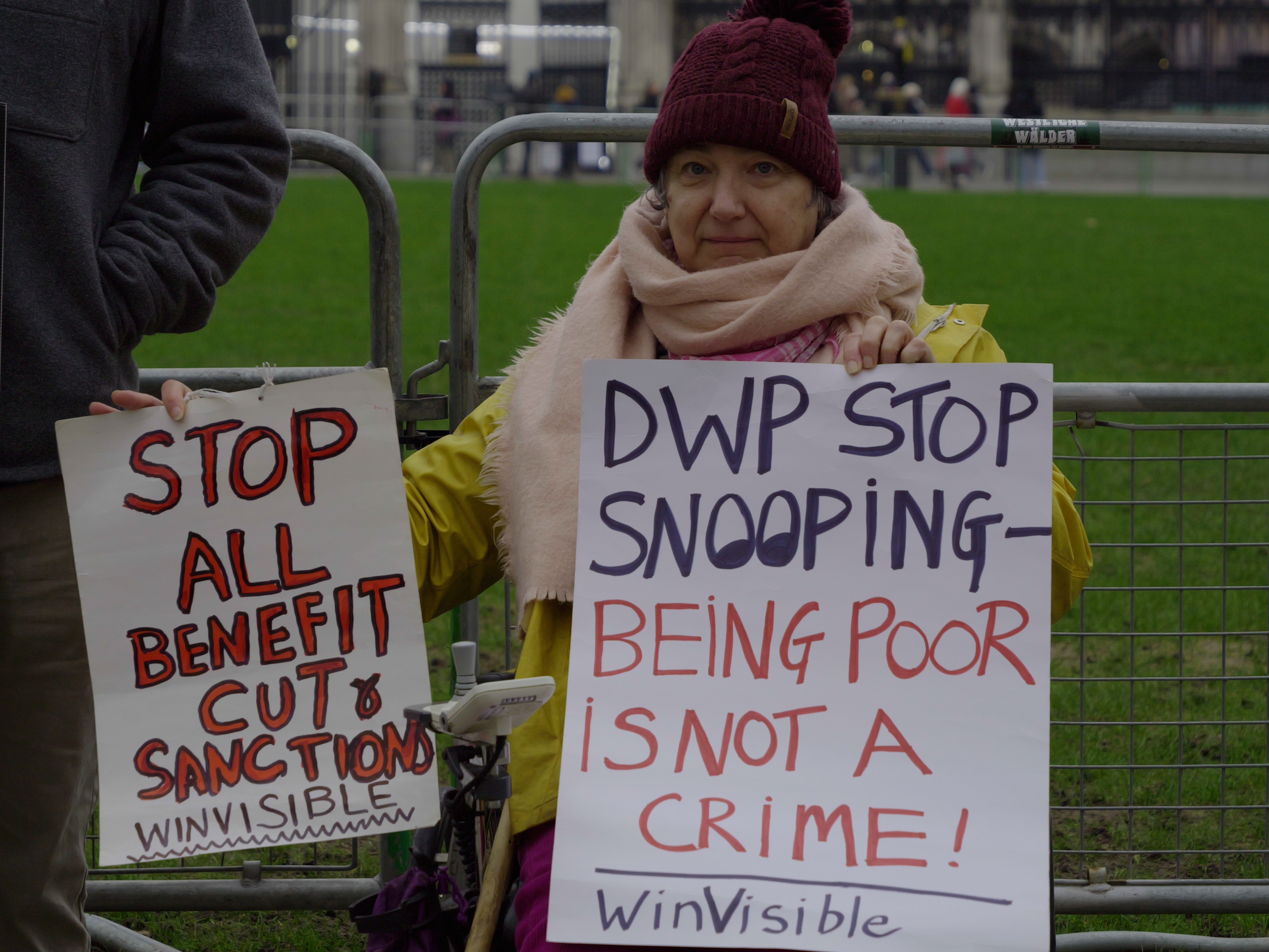Winvisible campaigner holding sign: DWP stop snooping on the poor